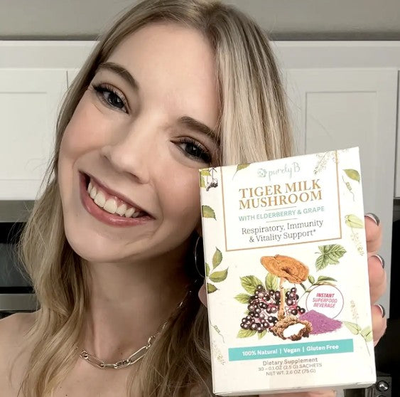 Customer holding PurelyB Tiger Milk Mushroom box and sachet