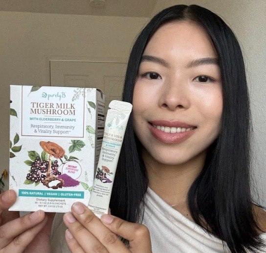 Hands holding PurelyB Tiger Milk Mushroom box